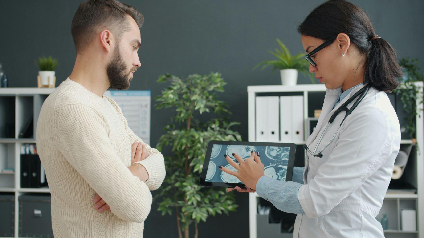 Quiropráctica le explica un estudio en una tableta a su paciente